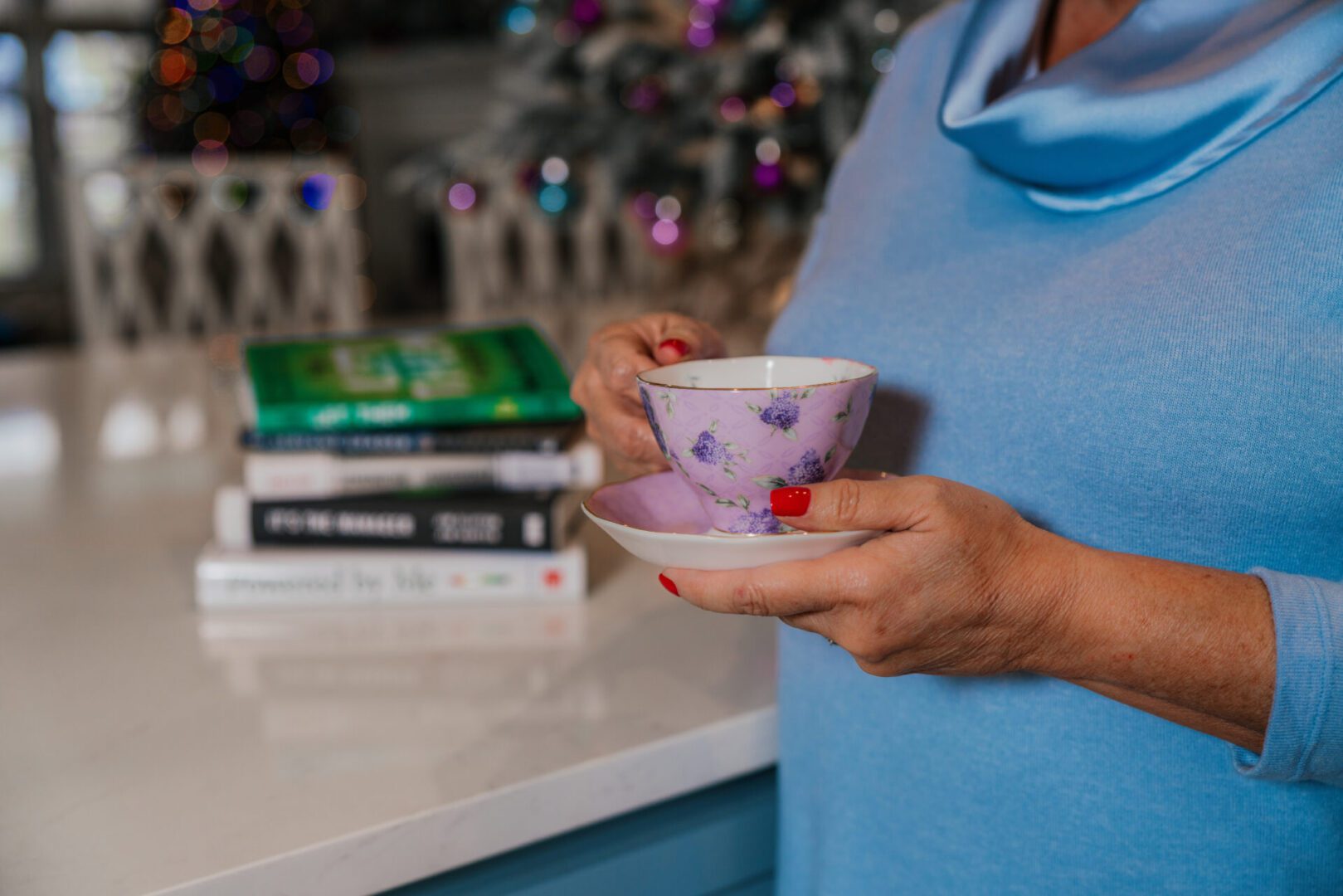 Person holding floral teacup and saucer