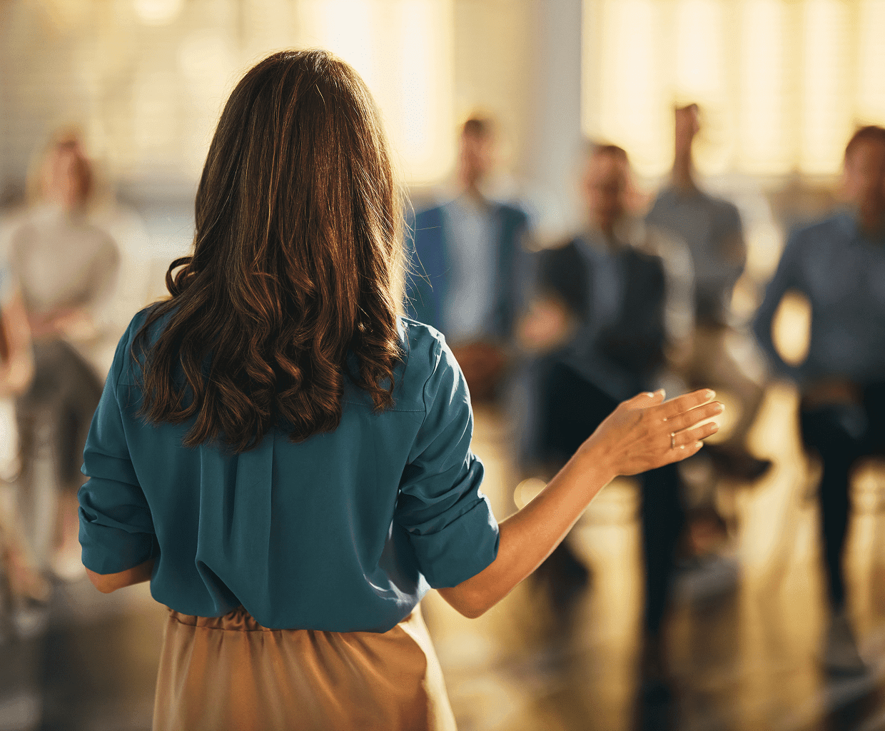 Businesswoman presenting to seated colleagues