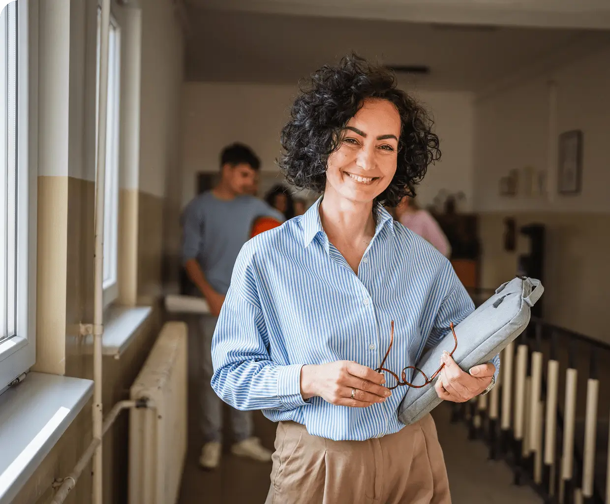 Smiling woman holding glasses and a folder
